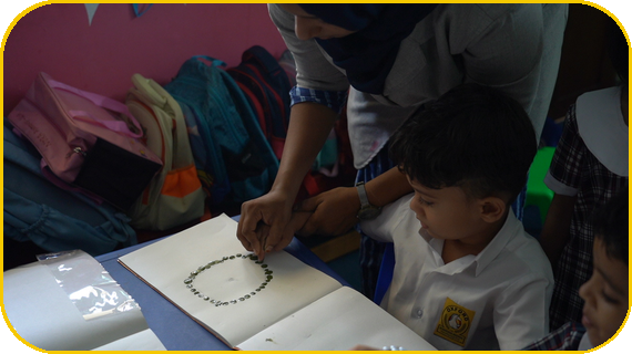 Teacher engaging with a young learner at the classroom table